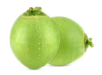 Close-up of fresh green fruit against white background