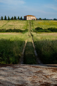 Road amidst field against sky