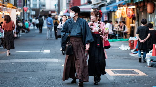 Group of people walking on road in city