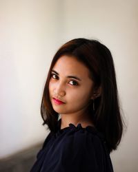 Portrait of asian girl smiling standing against wall