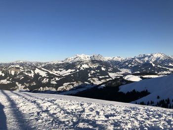 Scenic view of snowcapped mountains against clear blue sky
