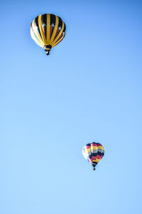 Low angle view of hot air balloon against clear blue sky