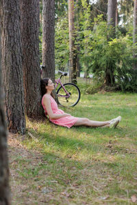 Side view of woman sitting on field