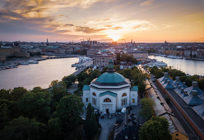 High angle drone shot of buildings against sky at sunset