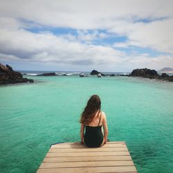 Rear view of young woman looking at sea