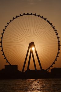Silhouette of bridge over river during sunset
