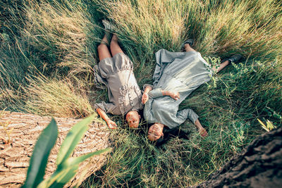 Serenity scene, two asian girls in flowing dresses find tranquility on grass, digital detox