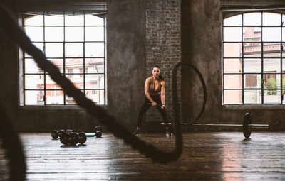 Full length of shirtless man looking through window