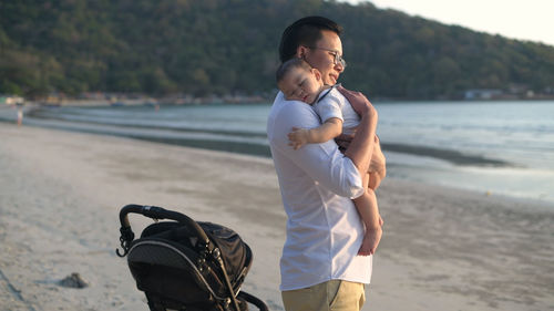 Man and baby standing at beach