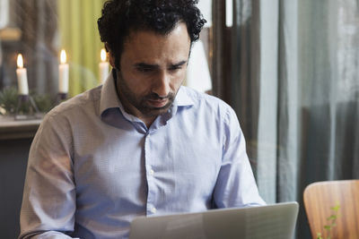 Concentrated blogger working on laptop in creative office