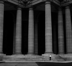 Man walking on steps of historical building