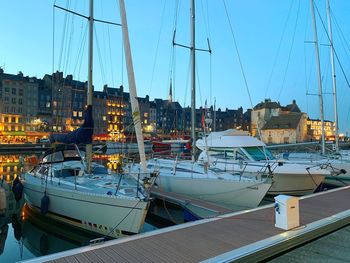 Sailboats moored at harbor in city