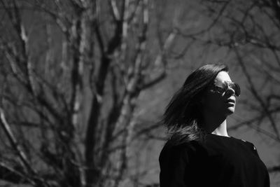 Woman standing on tree trunk