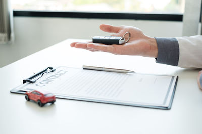 Midsection of man using mobile phone on table