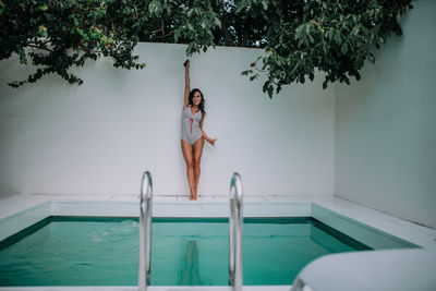 Young woman jumping in swimming pool