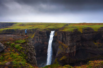 Scenic view of waterfall against sky