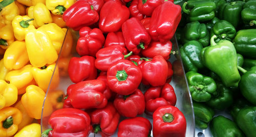 High angle view of bell peppers in containers at market for sale