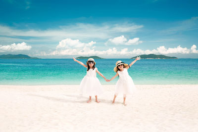 Full length of happy friends standing on beach