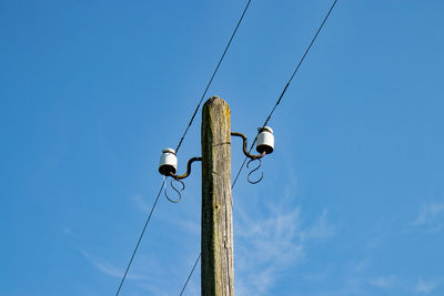 Low angle view of power lines against clear blue sky