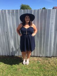 Full length of woman standing against fence