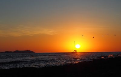 Scenic view of sea against orange sky