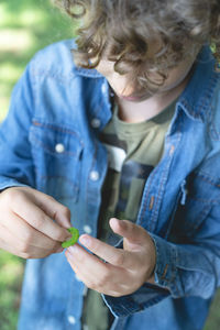 High angle view of boy holding insect