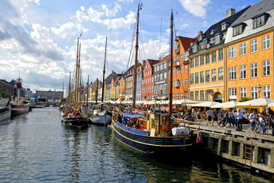 Sailboats moored on canal against buildings in city