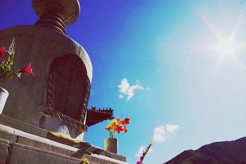 low angle view, architecture, built structure, building exterior, sun, sunlight, religion, sky, place of worship, clear sky, blue, spirituality, sunbeam, sculpture, famous place, lens flare, history, statue, travel destinations