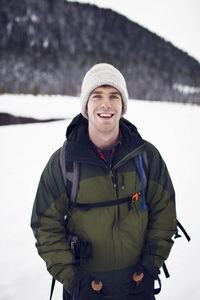 Portrait of hiker wearing warm jacket in field