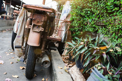 The image of a rusty old motorcycle parked on the side of the road.