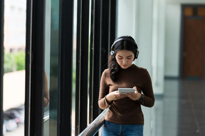 Full length of woman using mobile phone