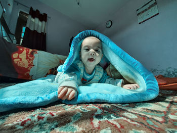 Portrait of boy lying on bed at home