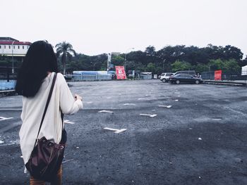 Rear view of woman walking on road