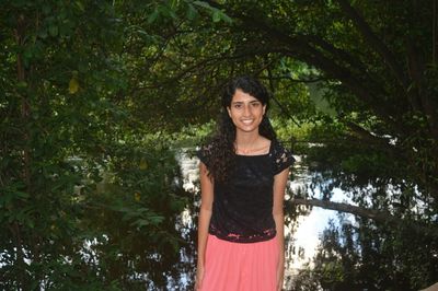 Portrait of smiling young woman standing against trees