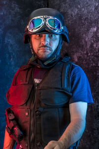 Portrait of male police officer standing against wall