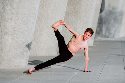 Young shirtless man exercising outdoors