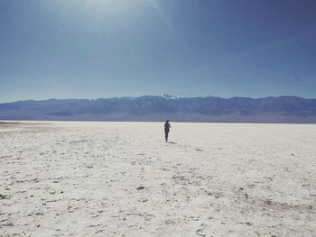 Woman running at beach against sky