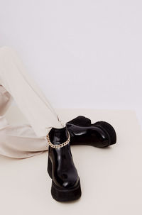 Details of trendy casual fall spring outfit. woman wearing white jeans and black platform boots.