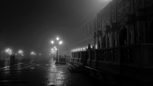 Illuminated street at night with fog