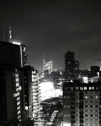 Modern buildings in city against sky at night