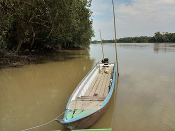 Sailboat moored on lake against sky