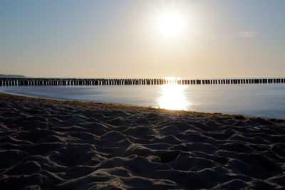 Scenic view of beach against clear sky during sunset