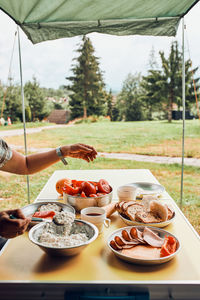 Breakfast prepared during summer vacation on camping. bread, cottage cheese, cold meat, tomatoes