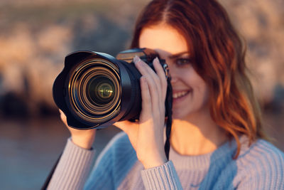 Portrait of smiling woman holding camera