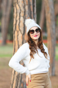 Portrait of young woman wearing sunglasses standing outdoors