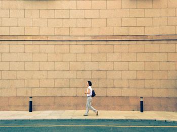 Full length of young man standing on wall