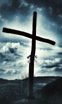 Cross on landscape against sky