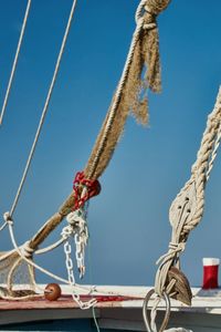 Low angle view of rope tied up against blue sky