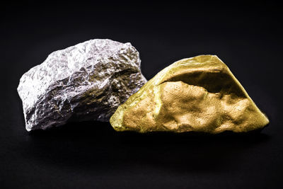 High angle view of bread on rock against black background