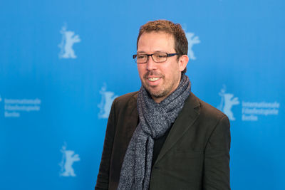 Portrait of smiling man standing against blue sky